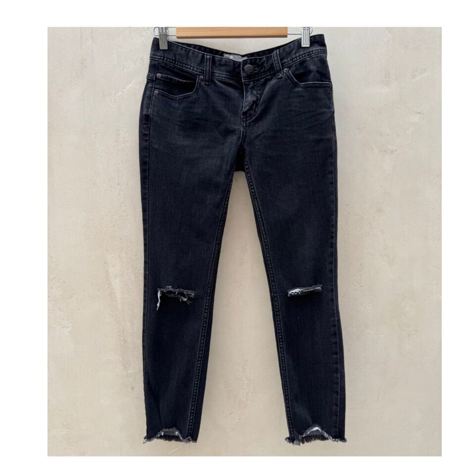 Jeans Free People Noir Vintage ultra-soft negros con roturas en las rodillas y bajo raw-cut asimétrico, talla 26