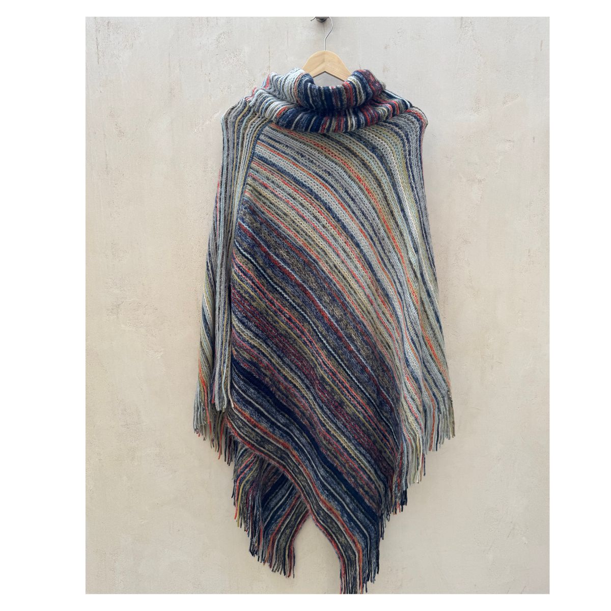 Poncho tejido multicolor con cuello alto y flecos talla única. Estilo boho chic