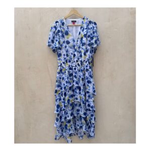 Vestido maxi floral en tonos oceánicos: capas de volantes vaporosos, estampado acuarela de flores índigo y amarillo sol sobre blanco puro. Cintura smocked y mangas flutter para un look cottagecore