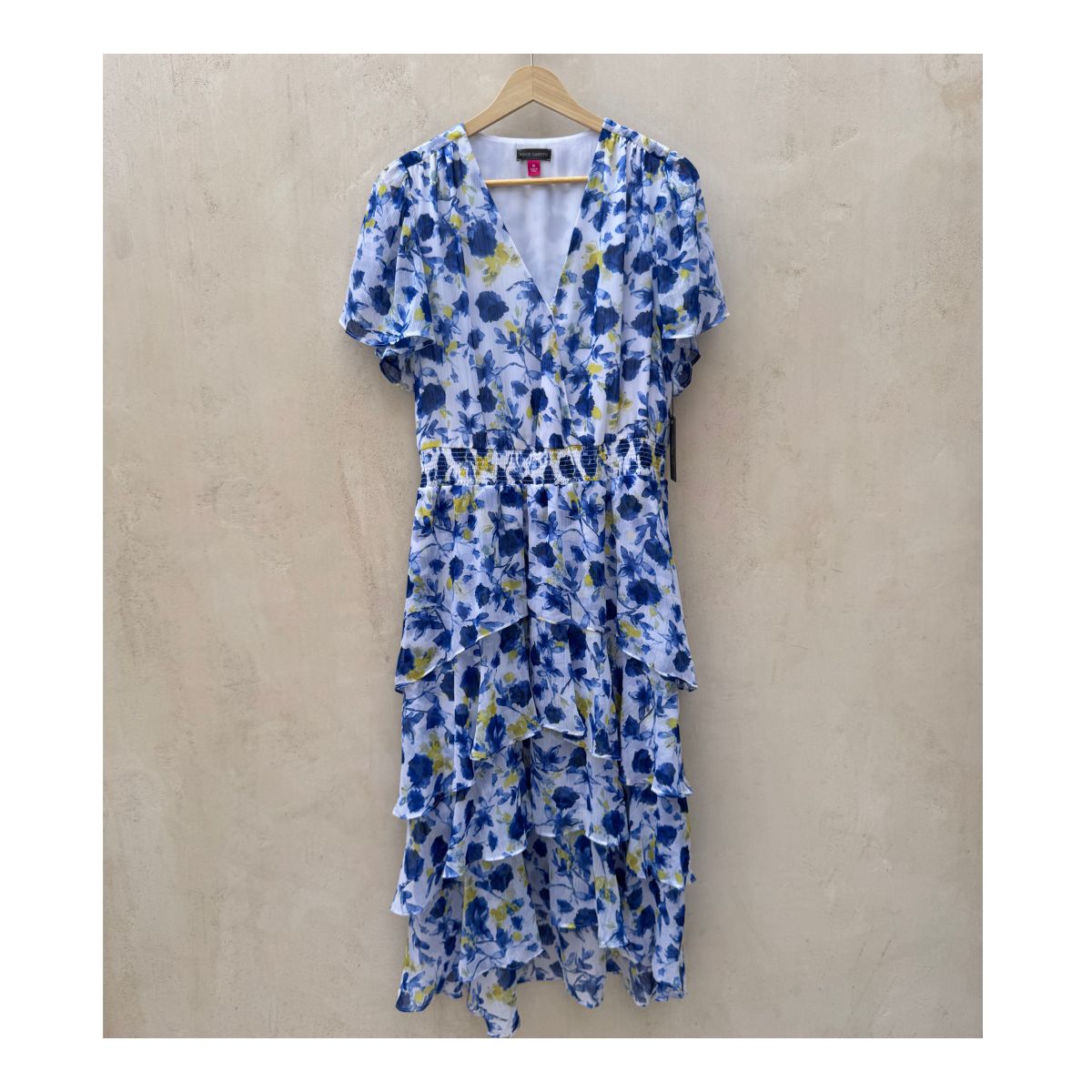 Vestido maxi floral en tonos oceánicos: capas de volantes vaporosos, estampado acuarela de flores índigo y amarillo sol sobre blanco puro. Cintura smocked y mangas flutter para un look cottagecore