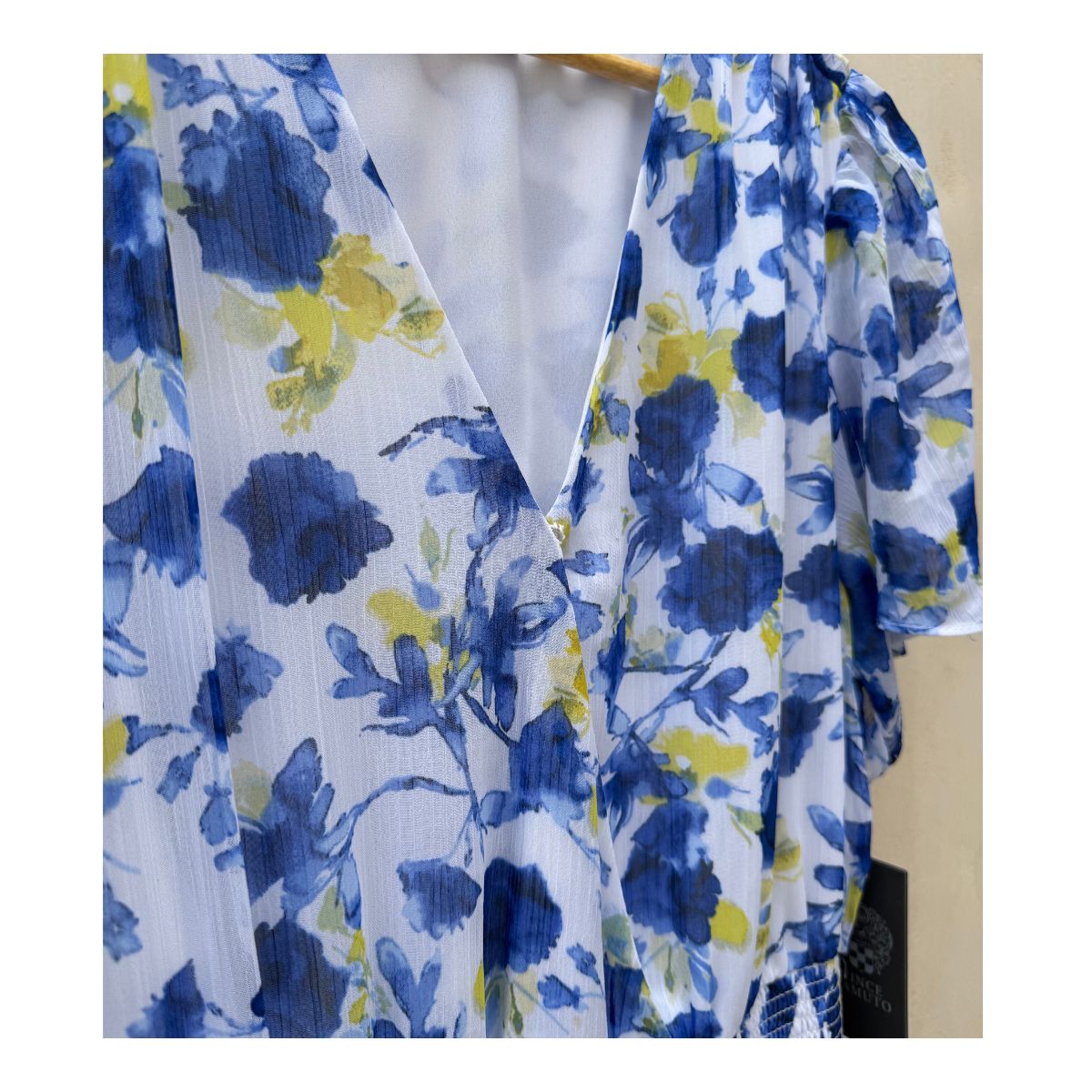 Vestido maxi floral en tonos oceánicos: capas de volantes vaporosos, estampado acuarela de flores índigo y amarillo sol sobre blanco puro. Cintura smocked y mangas flutter para un look cottagecore