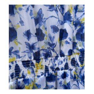 Vestido maxi floral en tonos oceánicos: capas de volantes vaporosos, estampado acuarela de flores índigo y amarillo sol sobre blanco puro. Cintura smocked y mangas flutter para un look cottagecore