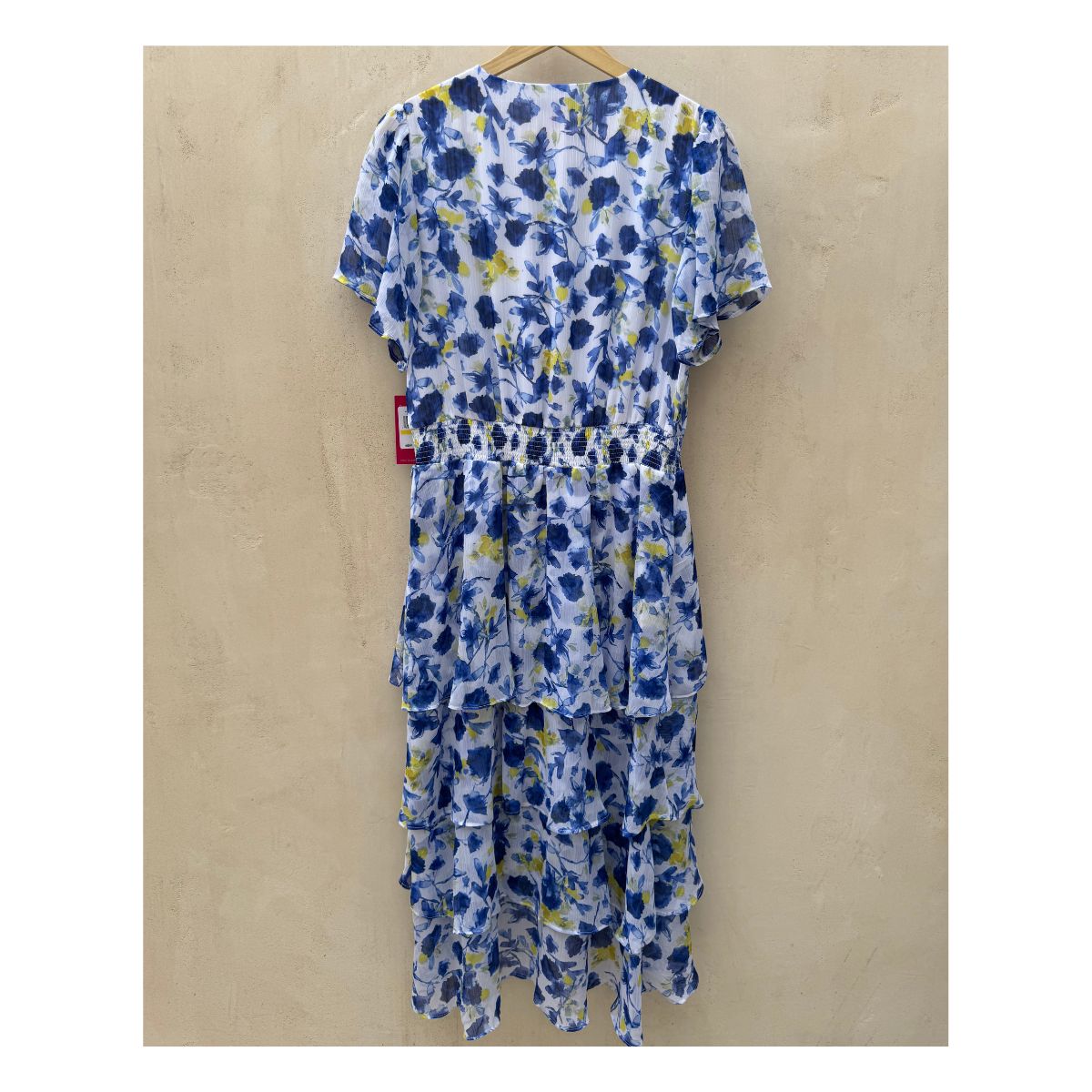 Vestido maxi floral en tonos oceánicos: capas de volantes vaporosos, estampado acuarela de flores índigo y amarillo sol sobre blanco puro. Cintura smocked y mangas flutter para un look cottagecore