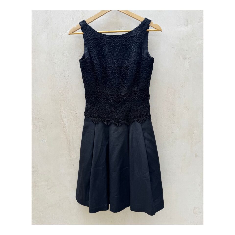 Vestido negro de segunda mano WHBM con encaje floral y falda plisada, talla 0, forrado y cierre invisible.ropa usada