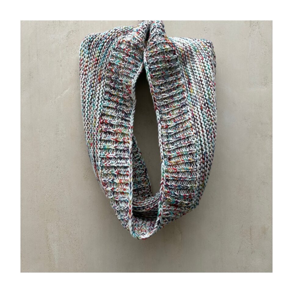 Bufanda infinita de Loft. En punto acanalado con explosión multicolor controlada. Aesthetic soft winter que fusiona arte abstracto y confort urbano.